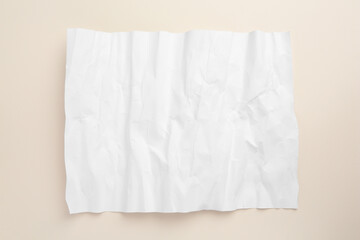 Sheet of crumpled parchment paper on beige background, top view