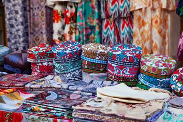 Uzbek traditional clothes such as skullcaps and other colorful souvenirs, Tashkent, Uzbekistan. 