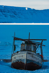 Shipwrecked Vessel Amidst the Snowy Coast of Greenland