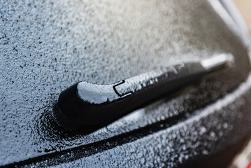 Rear car windscreen wipers frozen on winter morning. - obrazy, fototapety, plakaty