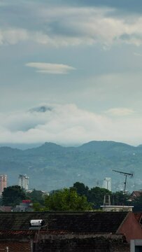 Vertical video - Timelapse of clouds rolling over the mountains