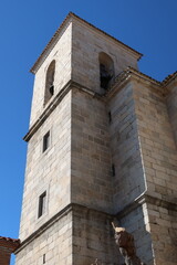 Fototapeta na wymiar Church of the Assumption, Cadalso de los Vidrios, Madrid, Spain, November 18, 2023: Tower of the Parish Church of the Assumption (16th century). Cadalso de los Vidrios, Madrid, Spain