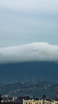 Vertical video - Timelapse of layers of clouds rolling over the mountains