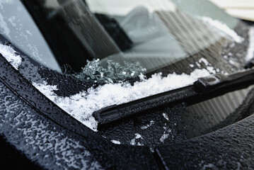 Frozen car windscreen wipers on winter morning. Close up view. - obrazy, fototapety, plakaty