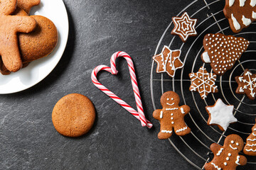 baking, cooking, christmas and food concept - close up of iced gingerbread cookies and candy canes...
