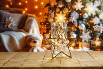 Fototapeta na wymiar Yellow old wooden table and free space for your decoration. Blurred home interior with christmas tree. Empty space for your products. Mockup background and magic december time. Natural light.