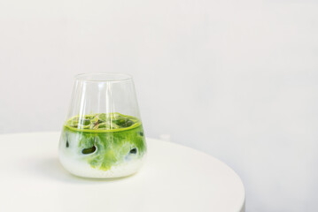 ice matcha latte on white table.