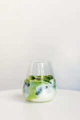 ice matcha latte on white table.