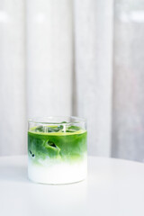ice matcha latte on white table.