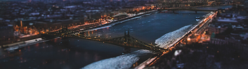 The magic panorama of the city at dusk, river, two bridge and city lights. Budapest Hungary, tilt-shift effect, toned - obrazy, fototapety, plakaty