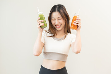 Orange, green detox juice, smile asian young woman hand holding bottle of vegetable juice, carrot...