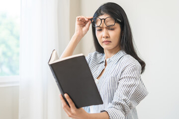 Presbyopia, hyperopia middle aged asian woman holding eyeglasses problem with vision blurred,...