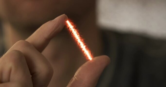 Red stream of energy appears between fingers. Visual effect, close-up. Concept of measuring distance, power, knowledge of the universe, sorcery, magic, electricity, body energy.
