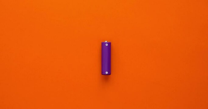 Battery and lightning bolts flying from it on an orange background. 4K stop motion animation