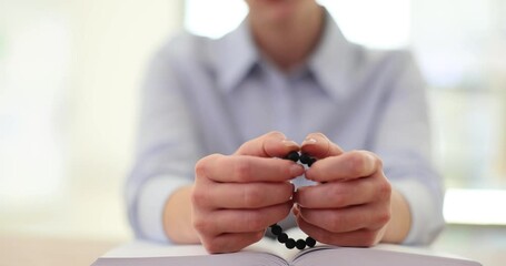 Bible rosary and hands of a woman in prayer studying religion at table at home with Christian faith and knowledge of God - Powered by Adobe