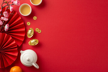 Celebrate Chinese New Year in grand style. Top view of vibrant red fans, tea ceremony set, lavish...