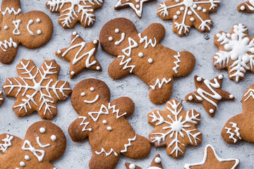 Homemade gingerbread Christmas cookies in icing sugar. Delicious gingerbread cookies on the background of a bokeh of Christmas tree lights. Freshly baked Christmas gingerbread cookies.