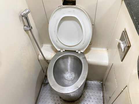 A stainless steel toilet that has just been used for urination and has not been flushed. Foamy urine in smelly public toilets on trains.