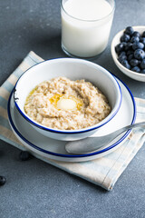 Oatmeal porridge in white bowl, close up view.Oatmeal bowl. Oat porridge with banana, blueberry, walnut, chia seeds and oat milk for healthy breakfast. Healthy diet food. Top view