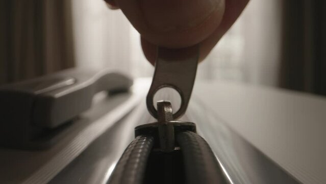 Zipper on suitcase. Unzipping gray travel luggage. Unknown male fingers pull zipper tab. Moving to new apartment or home. Start of new chapter of change and improvement, relocate settle into new life