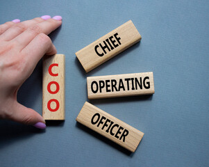 COO - Chief Operating Officer symbol. Concept word COO on wooden blocks. Businessman hand. Beautiful grey background. Business and COO concept. Copy space. - obrazy, fototapety, plakaty