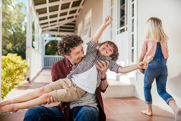 Joyful little boy having fun with father in backyard