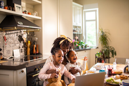Single mother having breakfast with her two young daughters at home