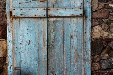 rustic old painted window or door in stone building house, abandoned property