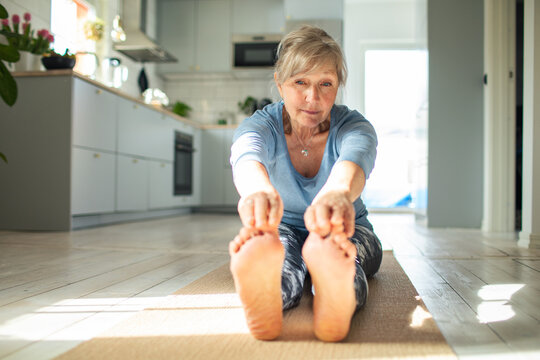 Morning Stretch: Senior Woman Practicing Yoga at Home
