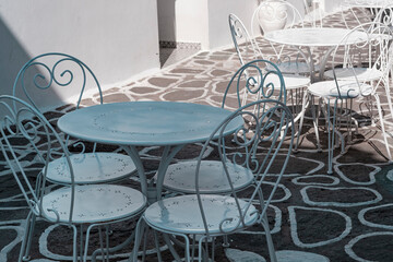 cozy street cafe in Greece, greek traditional cobblestoned streets, white table and chairs,...