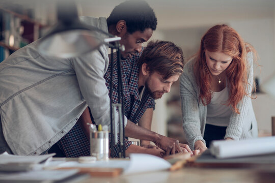 Young and diverse group of architects working on a project together in a startup company office
