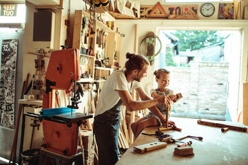 Father and Daughter Enjoying Craft Time in a Woodworking Workshop