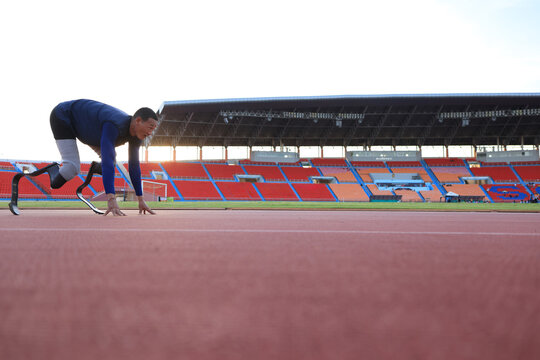 disabled male athlete with a running blade ready to start a run