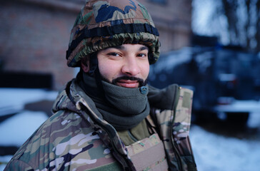 Outdoors portrait of a Ukrainian military soldier in full body armor and ballistic helmet