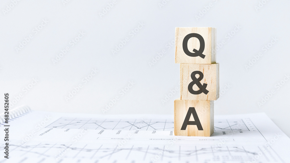 Aufkleber text q and a on wooden cube blocks stack on wood table on white background with copy space