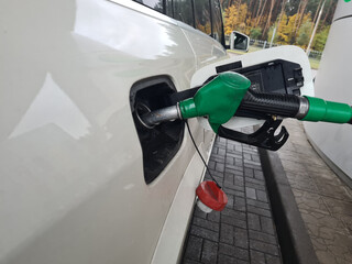 Pistol with fuel in gas tank of white car