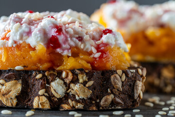 Bread slices with cheese, stewed pumpkin pulp, honey and jam on wooden board. Delicious breakfast on morning. Closeup