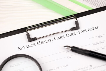 Advance health care directive blank form on A4 tablet lies on office table with pen and magnifying...