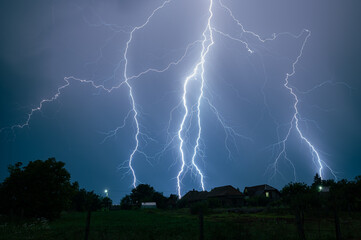 Branched thunderbolts of lighting are hitting the earth at night