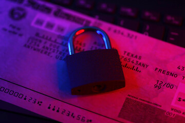 United States Treasury refund check or stimulus bill with small padlock on computer keyboard close...
