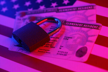 Permanent resident green card for US DV-lottery with small padlock on US flag close up