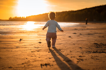 Little baby child toddler walks along an empty beach by the sea at sunset alone, calm and relax, active childhood - Powered by Adobe