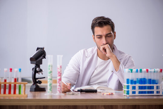 Young male chemist in front of white board - Powered by Adobe