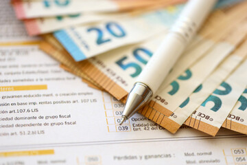 Filling italian tax form process with pen and euro money bills close up. Tax paying period and...