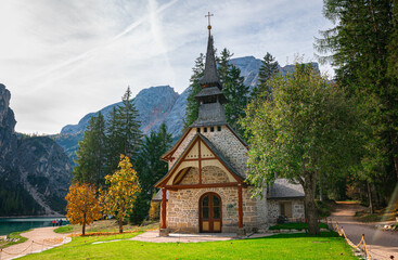 Fototapeta na wymiar Scenic chapel or little church on the shore of famous Braies Lake in the Dolomite Mountains