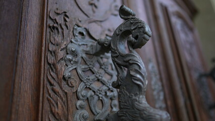 Beautiful ancient door filled with adornment, doorknob and ornamentation. Aesthetic antique traditional craftsmanship