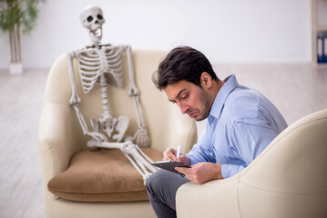 Young male psychologist meeting with skeleton