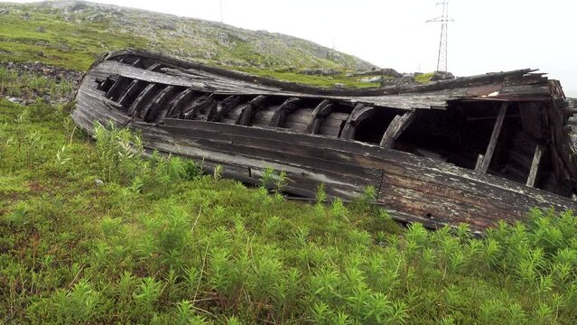 An old fishing whale-boat collapses on the shore of the Barents Sea. Kola Peninsula