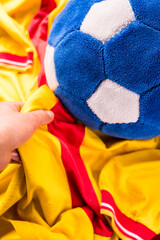 Hand taking blue soccer ball on yellow soccer shirt with copy space