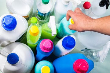 Top view of hand taking some liquid soap bottles on blue background